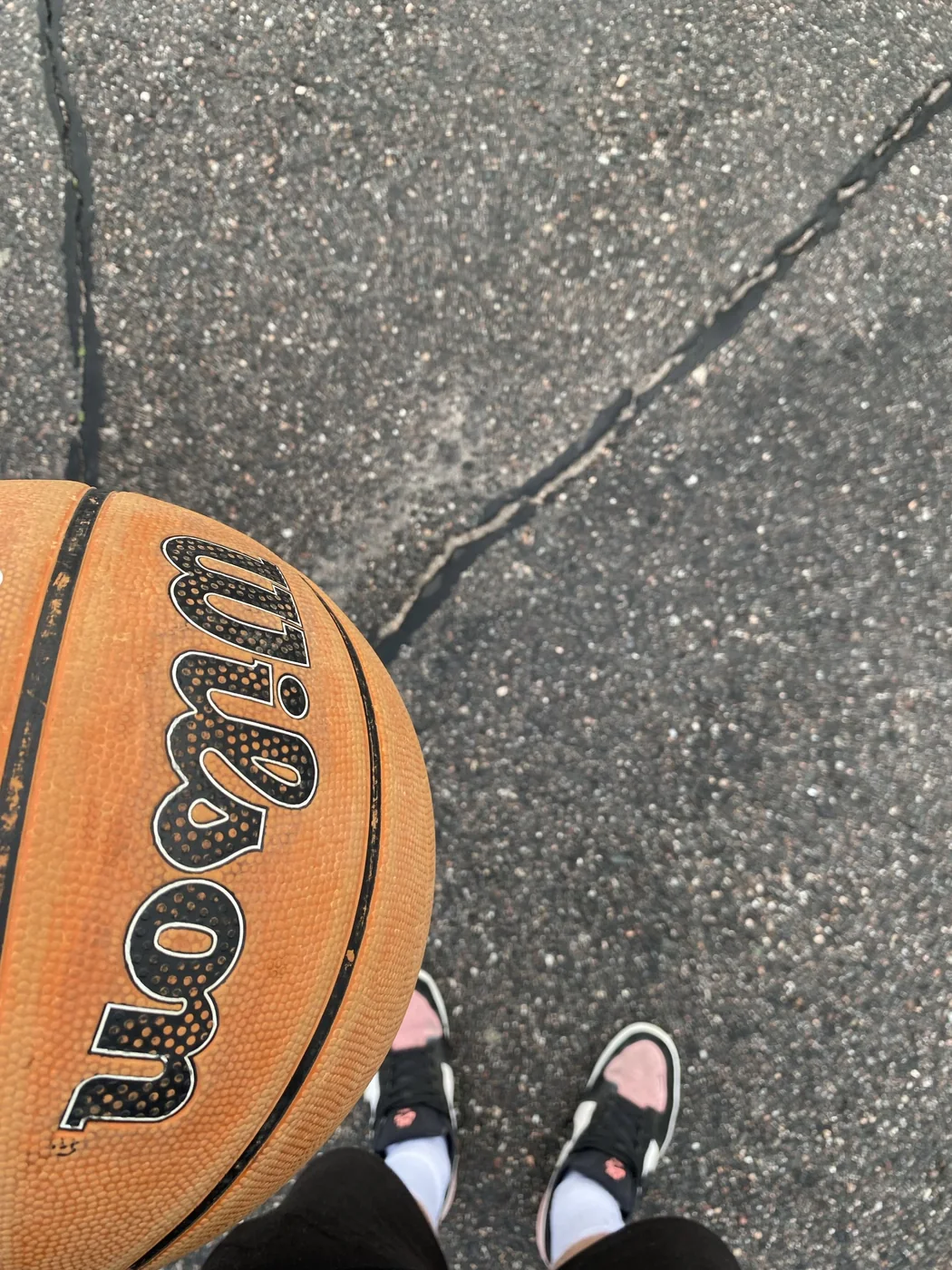 A basketball held while standing on an outdoor court