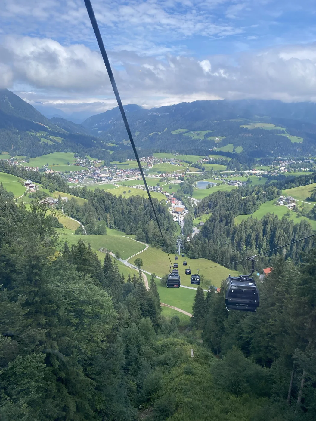A cable car crossing a green mountain valley